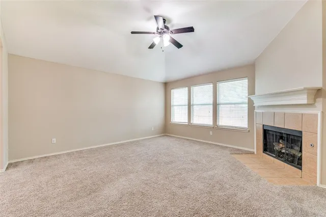 a view of an empty room with a fireplace and a window