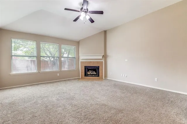 a view of empty room with fan and windows