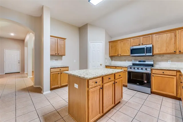 a kitchen with stainless steel appliances granite countertop a stove top oven and cabinets