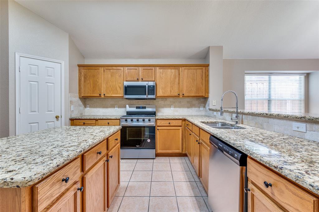 1117 Red Hawk Drive Frisco, TX 75033 - Photo 8 of 31 a kitchen with stainless steel appliances granite countertop a sink stove and cabinets
