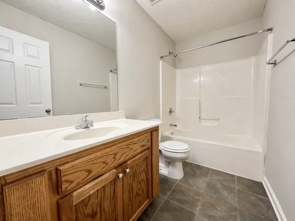a bathroom with a granite countertop sink toilet a large mirror and shower