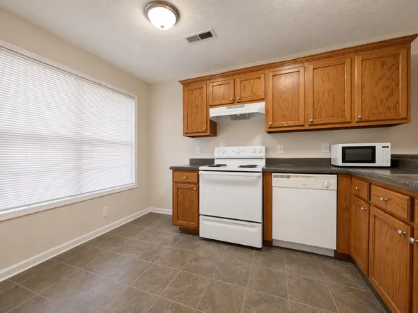 a kitchen with white cabinets and white appliances
