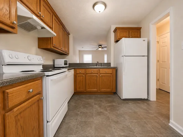 a kitchen with stainless steel appliances granite countertop a refrigerator sink stove microwave and cabinets