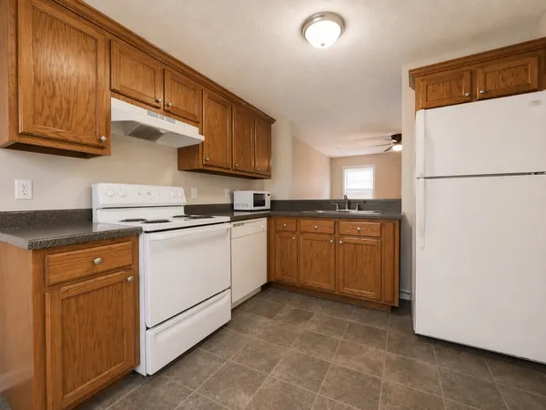 a kitchen with a sink a refrigerator and cabinets
