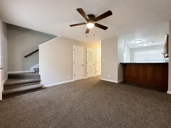 an empty room with windows and ceiling fan