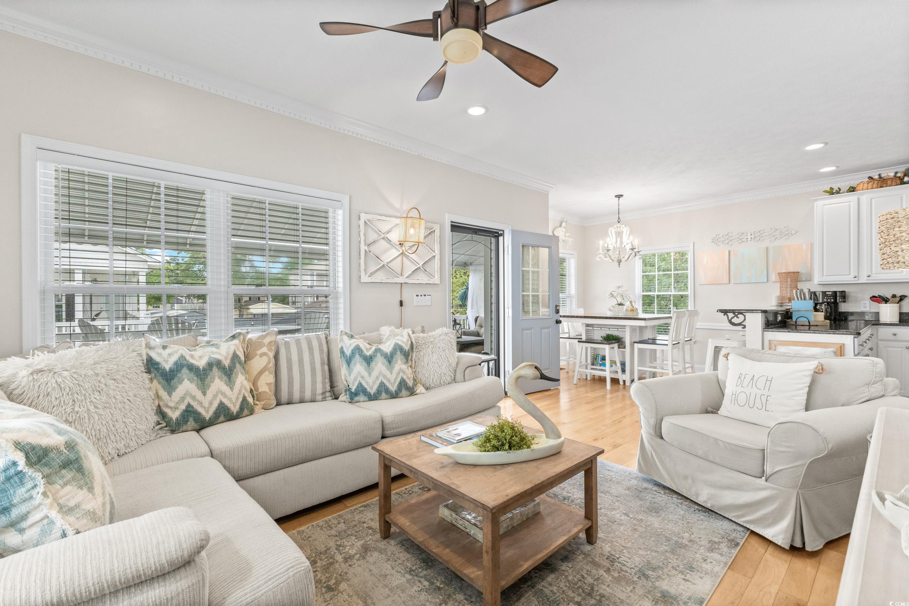 6001-1846a South Kings Highway Myrtle Beach, SC 29575 - Photo 16 of 40 Living room with ceiling fan with notable chandelier, light hardwood / wood-style floors, and ornamental molding