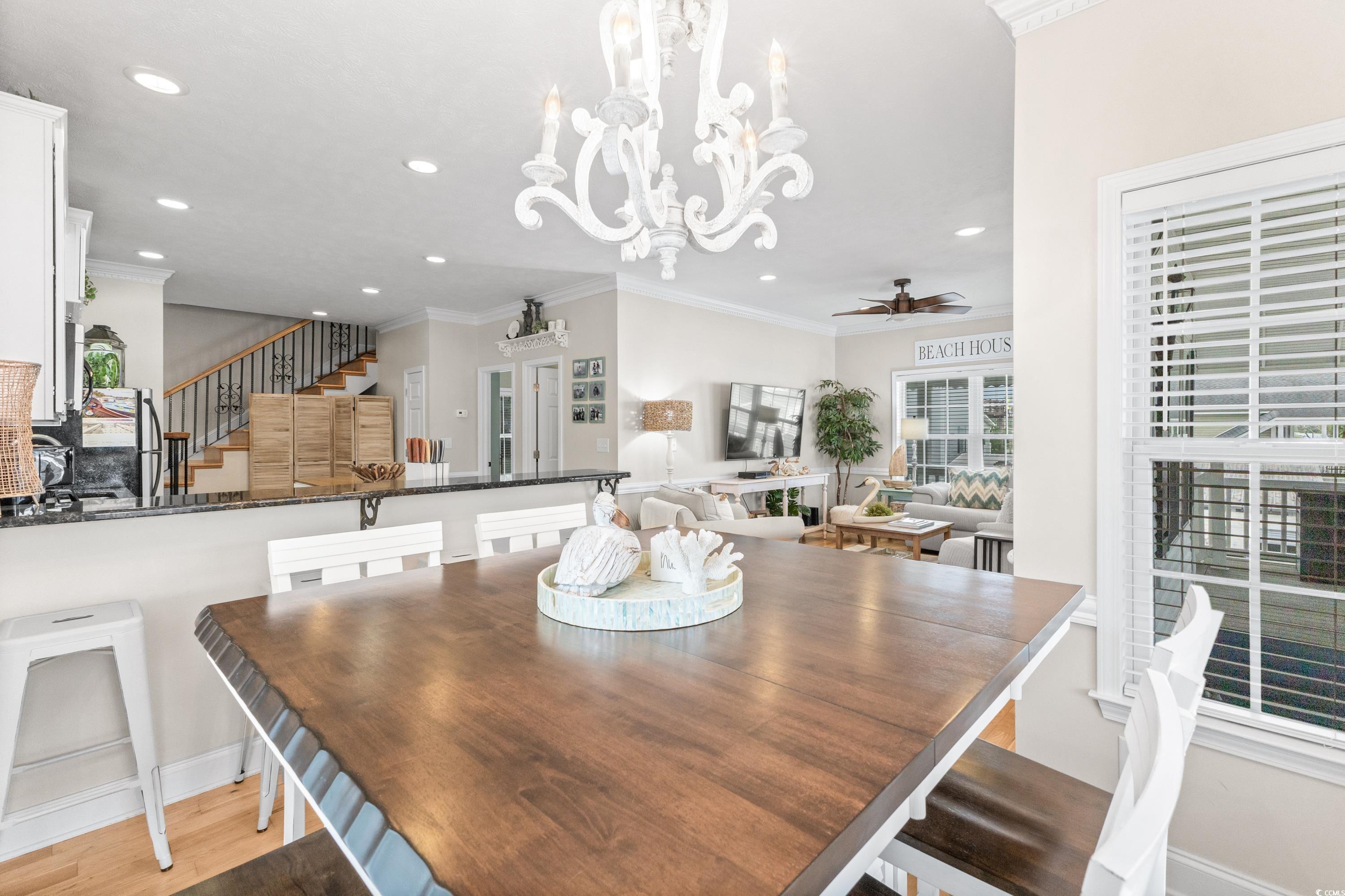 6001-1846a South Kings Highway Myrtle Beach, SC 29575 - Photo 18 of 40 Dining room with light hardwood / wood-style floors, ceiling fan with notable chandelier, and crown molding