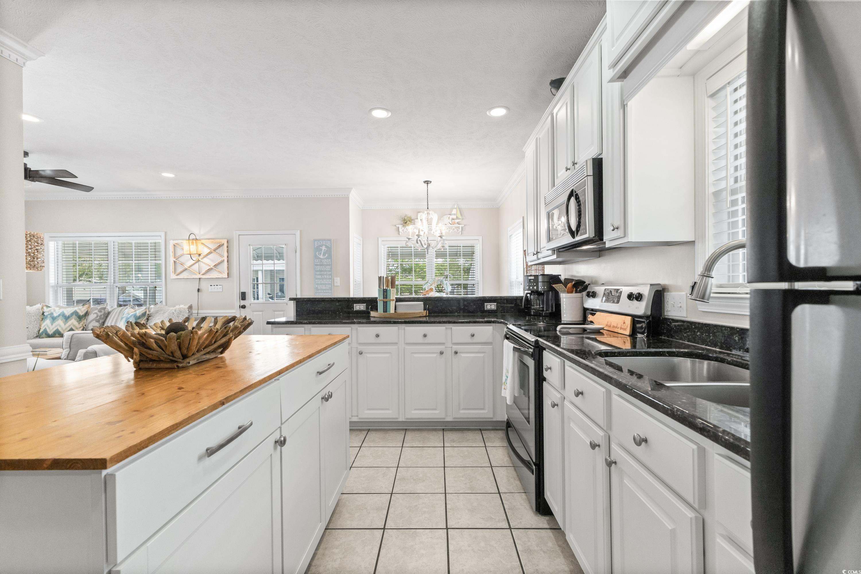 6001-1846a South Kings Highway Myrtle Beach, SC 29575 - Photo 21 of 40 Kitchen with plenty of natural light, appliances with stainless steel finishes, ornamental molding, and white cabinetry