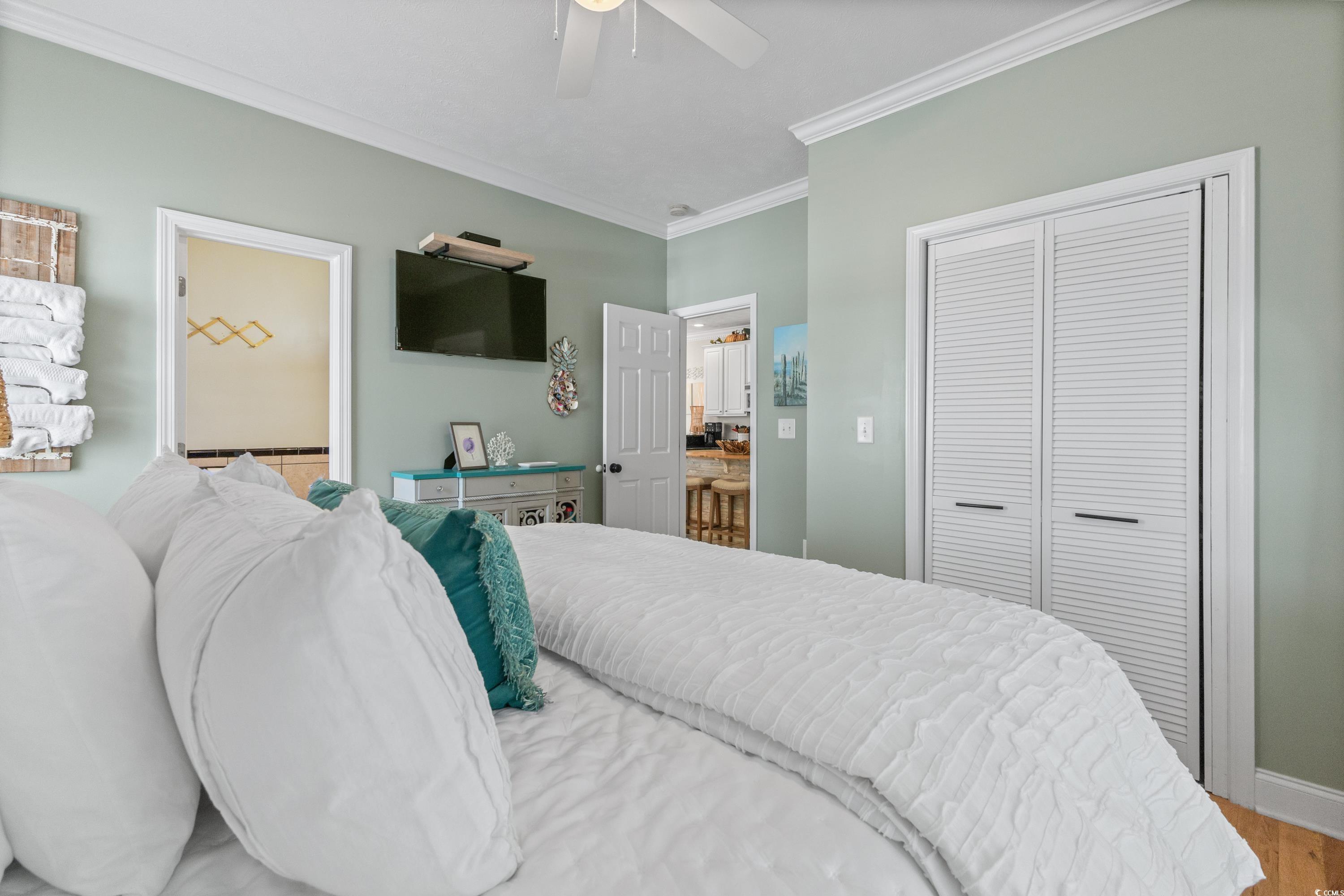 6001-1846a South Kings Highway Myrtle Beach, SC 29575 - Photo 26 of 40 Bedroom with a closet, ceiling fan, hardwood / wood-style floors, and crown molding