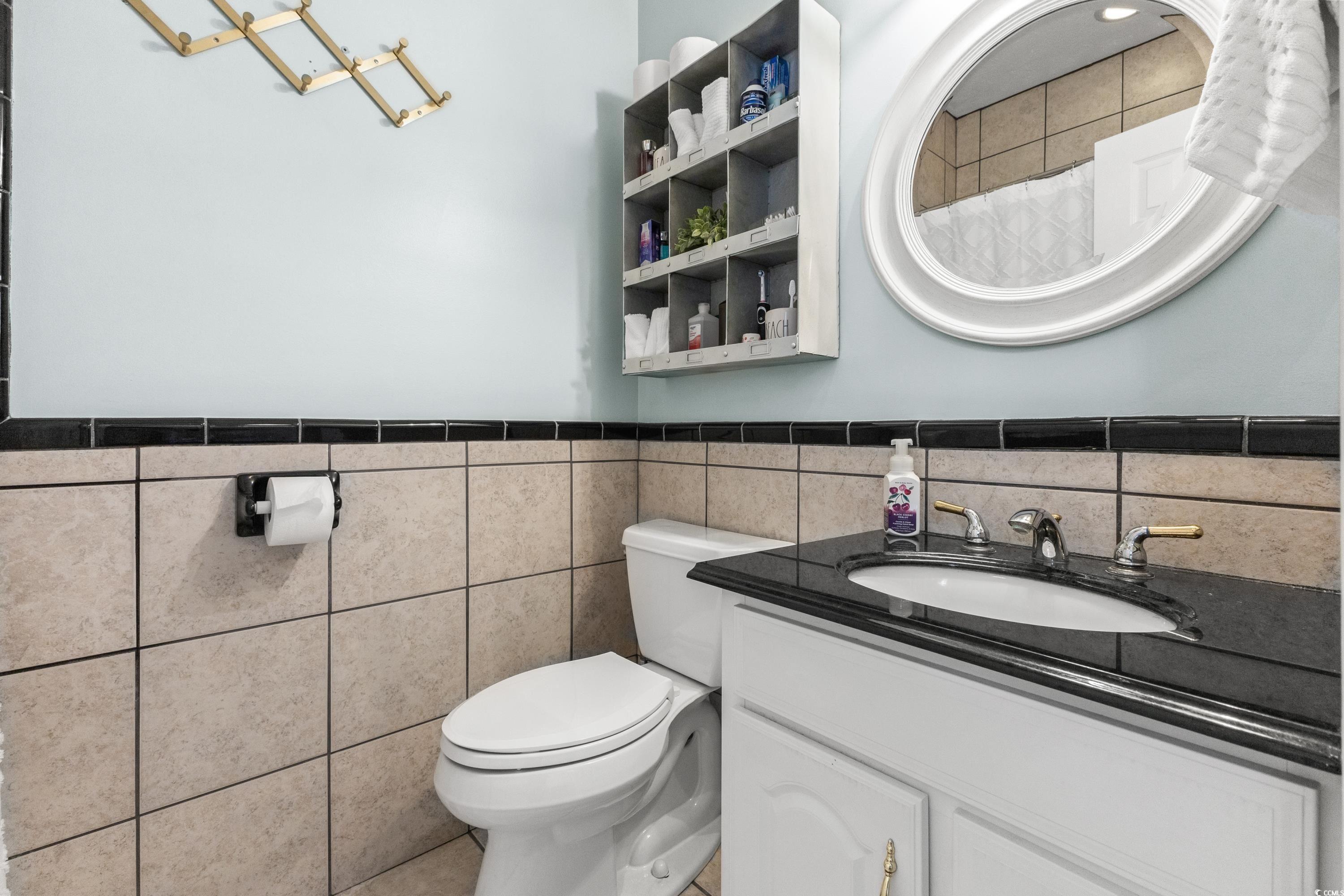 6001-1846a South Kings Highway Myrtle Beach, SC 29575 - Photo 27 of 40 Bathroom featuring tasteful backsplash, tile walls, tile patterned floors, toilet, and vanity