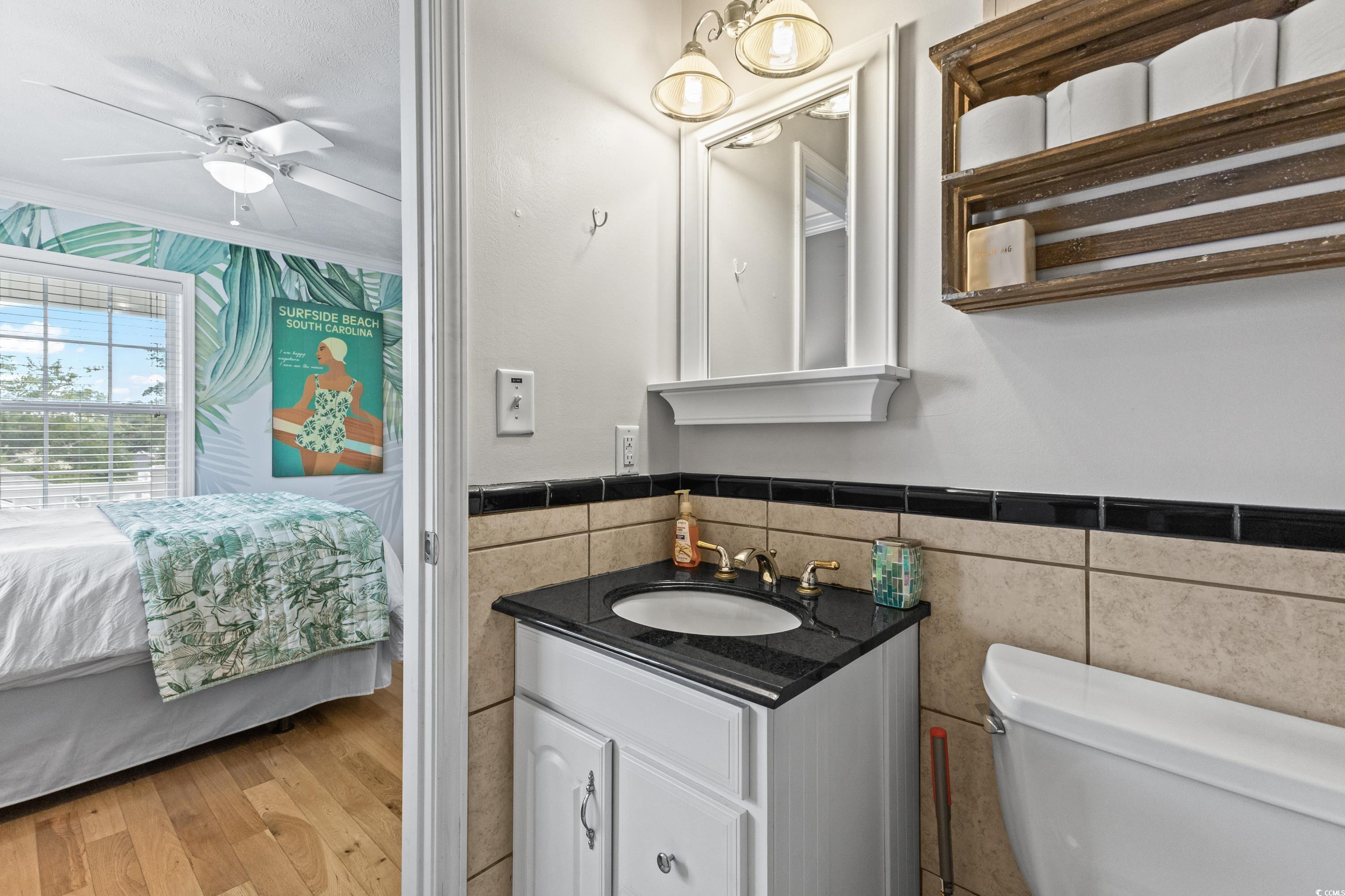 6001-1846a South Kings Highway Myrtle Beach, SC 29575 - Photo 31 of 40 Bathroom featuring vanity, hardwood / wood-style flooring, ceiling fan, ornamental molding, and toilet
