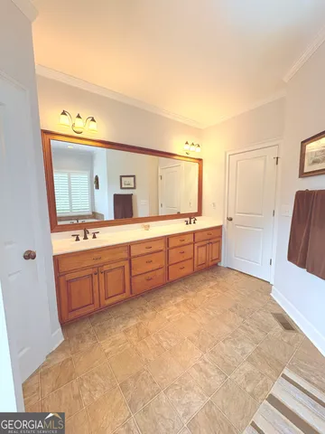 a large bathroom with a double vanity sink a mirror and a bathtub