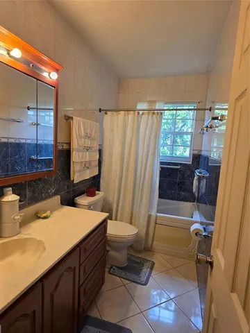 a bathroom with a sink a toilet a mirror and shower