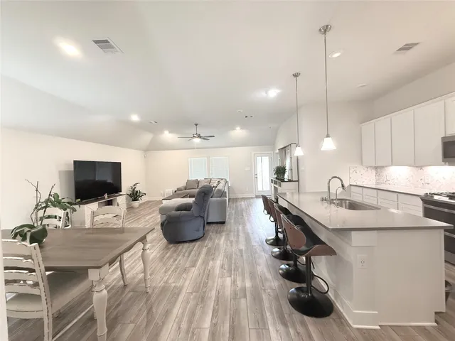 a kitchen with granite countertop a sink appliances and refrigerator