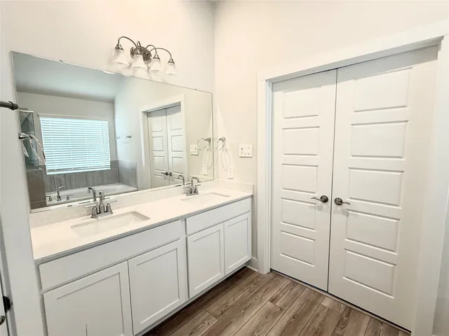 a bathroom with a tub a sink and a shower