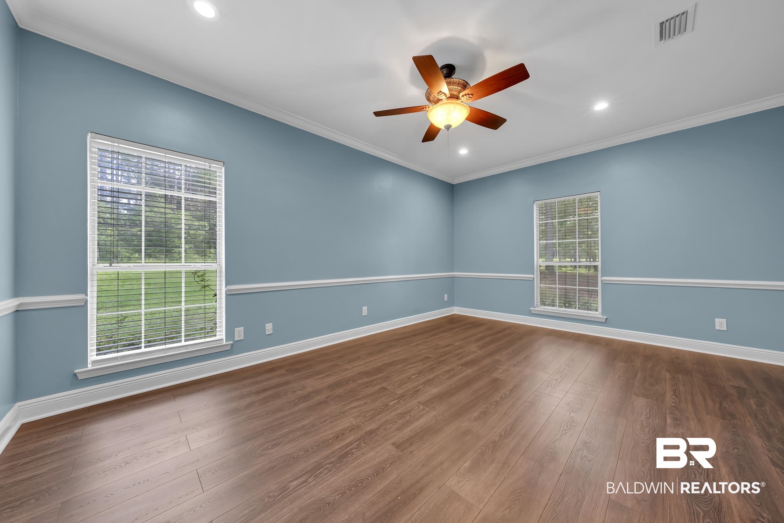 14960 Howells Ferry Road Wilmer, AL 36587 - Photo 12 of 22 Spacious room featuring wood-finish flooring and light blue walls with chair rail molding
