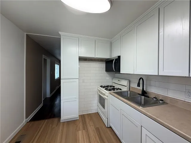 a kitchen with a sink a refrigerator and cabinets