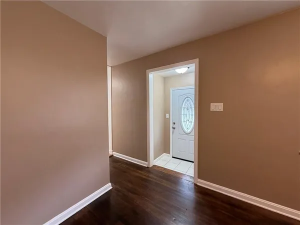 an empty room with wooden floor and closet