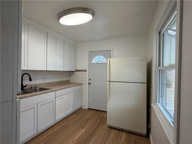 a kitchen with a refrigerator sink and cabinets