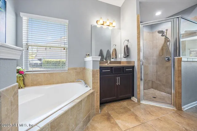 a spacious bathroom with a granite countertop tub sink and shower