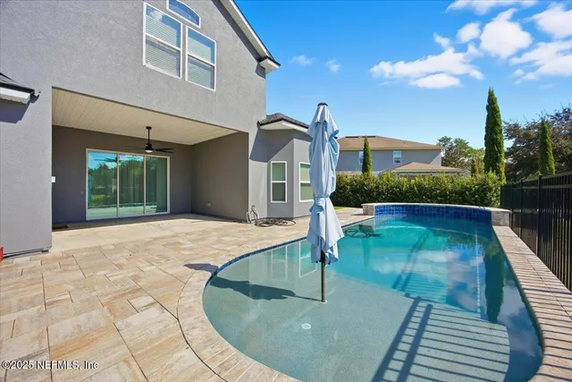 a view of a patio with table and chairs potted plants and a large tree