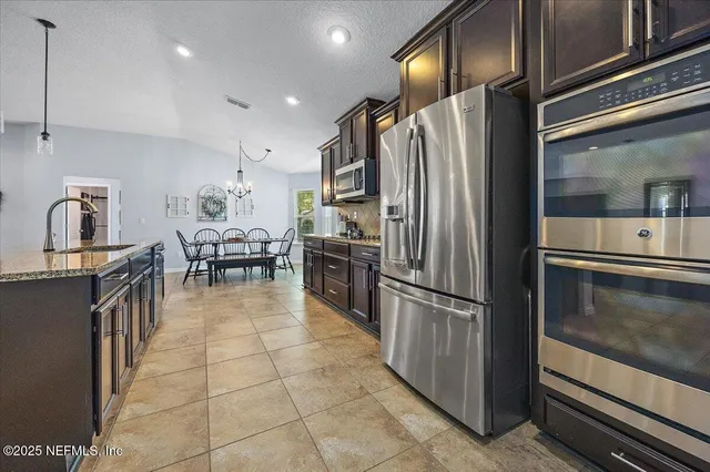 a kitchen with stainless steel appliances granite countertop a refrigerator and a stove