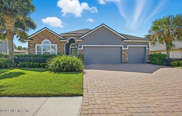 a front view of a house with yard and green space