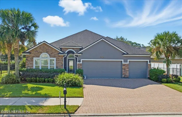 a front view of a house with a garden and plants