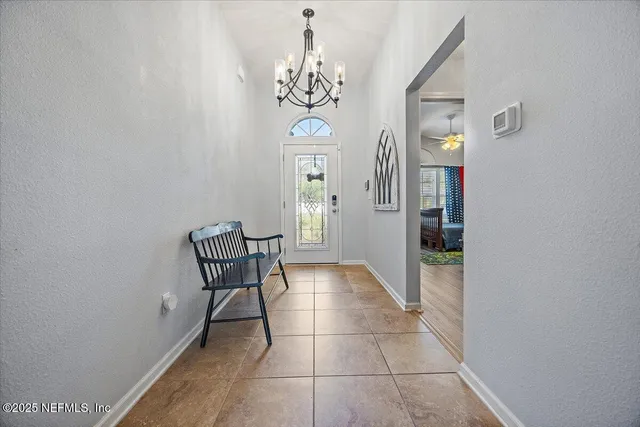 a view of a hallway with windows and chandelier