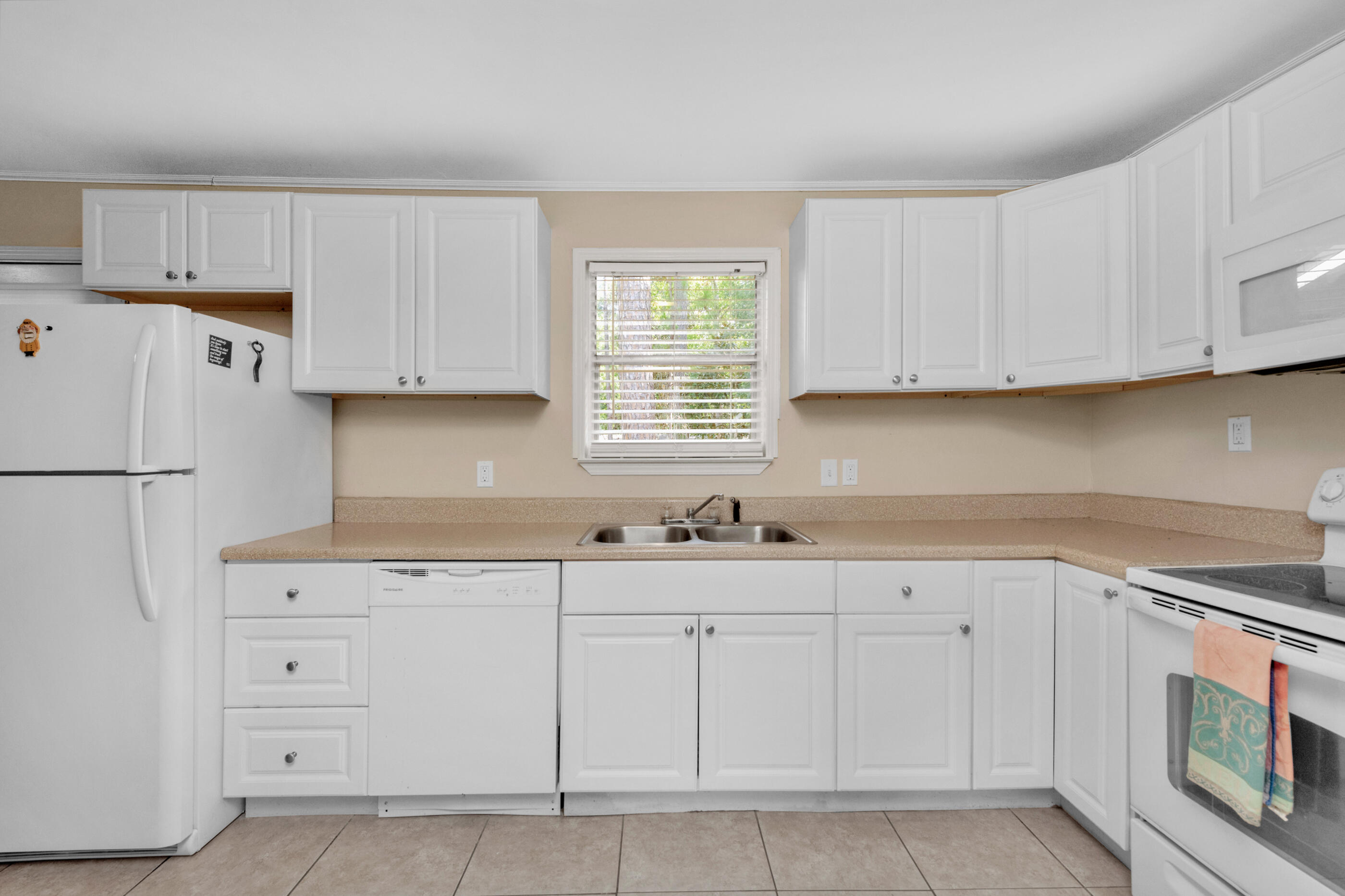 193 L Street Santa Rosa Beach, FL 32459 - Photo 11 of 24 a kitchen with white cabinets appliances a sink and a window