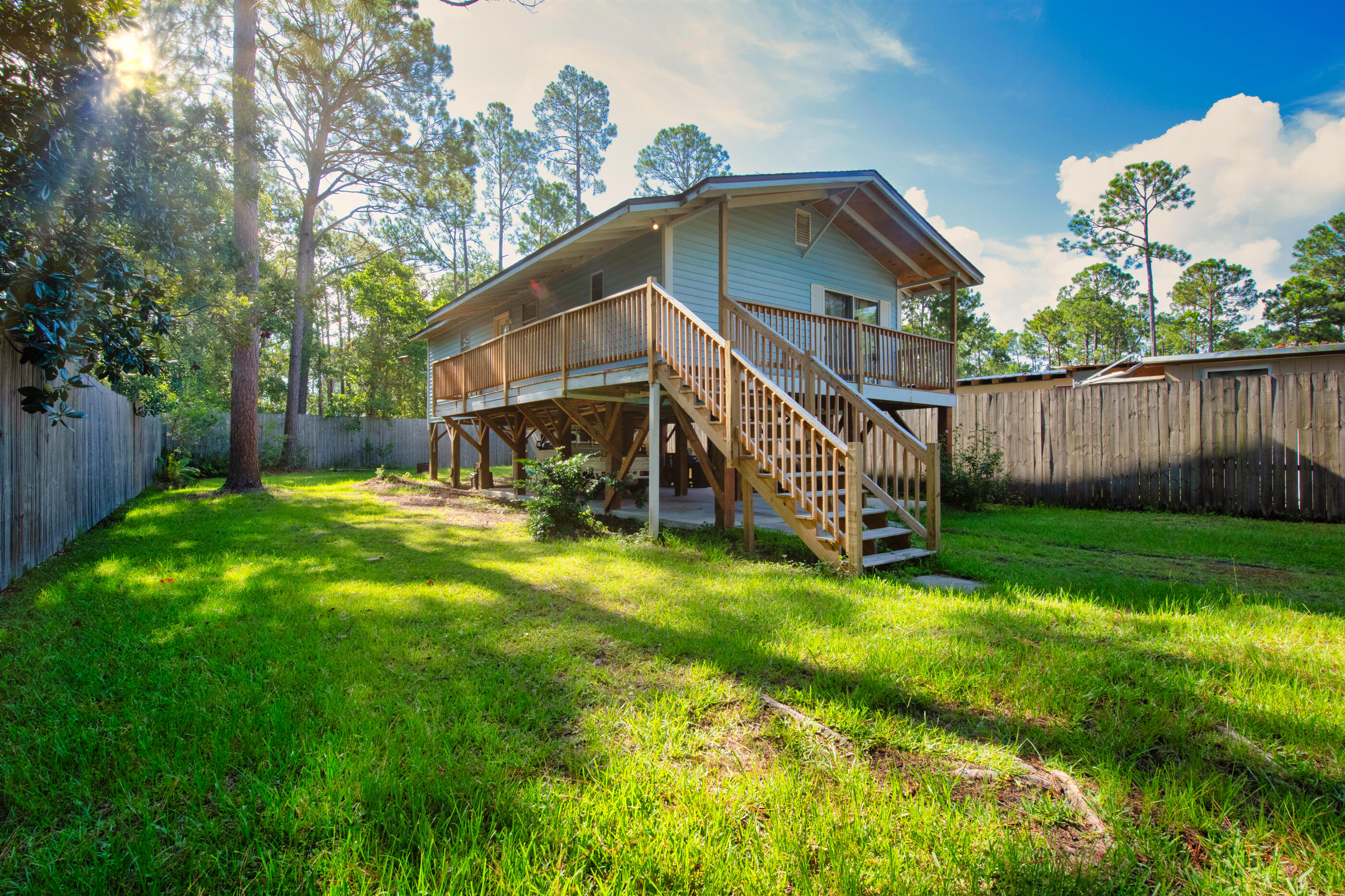 193 L Street Santa Rosa Beach, FL 32459 - Photo 3 of 24 a view of a big house with a big yard and large trees