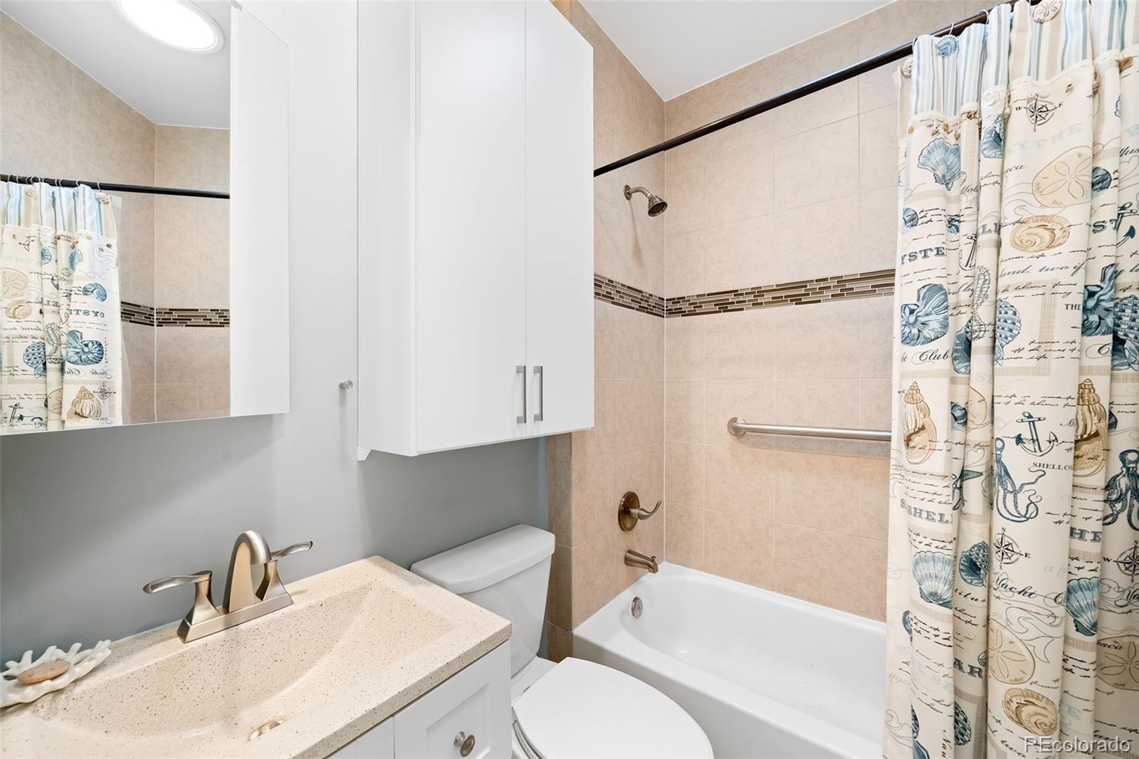 3059 Curtis Street Denver, CO 80205 - Photo 14 of 23 a bathroom with a sink toilet and shower