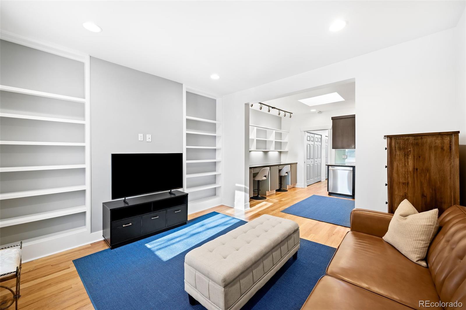 3059 Curtis Street Denver, CO 80205 - Photo 3 of 23 a living room with furniture and a flat screen tv