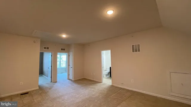 an empty room with closet and windows