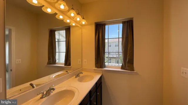 a bathroom with a double vanity sink a mirror and a bathtub