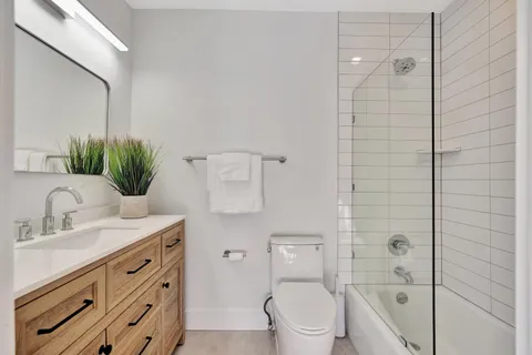 a bathroom with a granite countertop sink a toilet and shower
