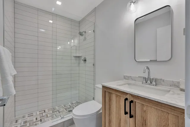 a bathroom with a granite countertop sink toilet and shower