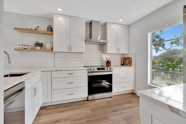 a kitchen with granite countertop white cabinets and appliances
