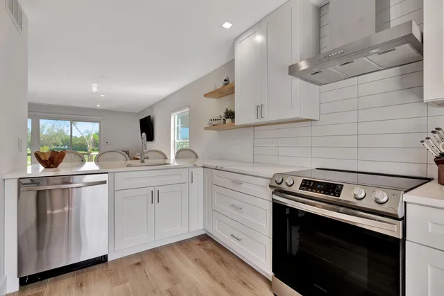 a kitchen with granite countertop white cabinets and white appliances