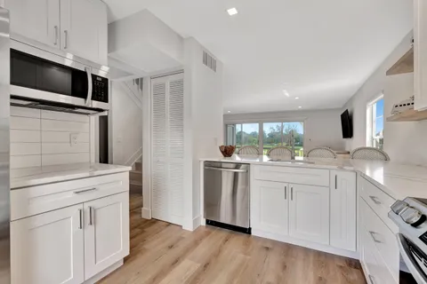 a kitchen with white cabinets and appliances
