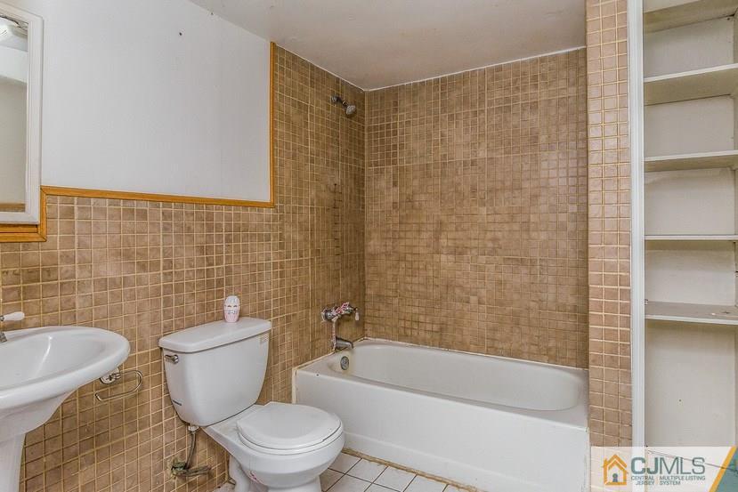 6 Mercury Road Edison, NJ 08817 - Photo 9 of 16 a white toilet sitting next to a bathroom sink and bathtub
