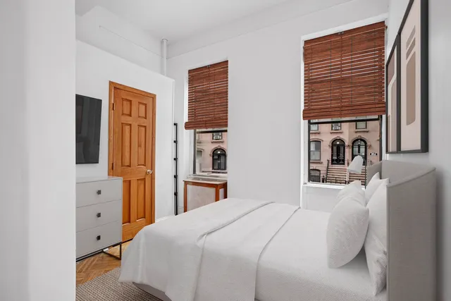 a bedroom with a bed and a refrigerator