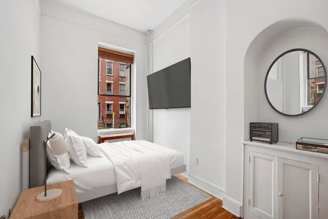 a bedroom with bed and a flat screen tv