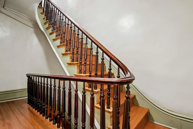 a view of staircase with railing and white walls