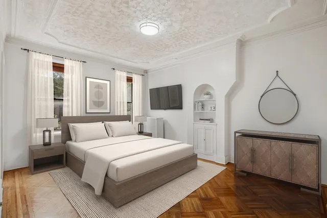 a bedroom with a large bed and a flat tv screen on dresser