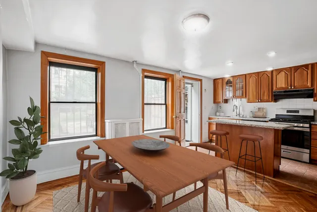 a open dining room with stainless steel appliances granite countertop a stove a table and chairs