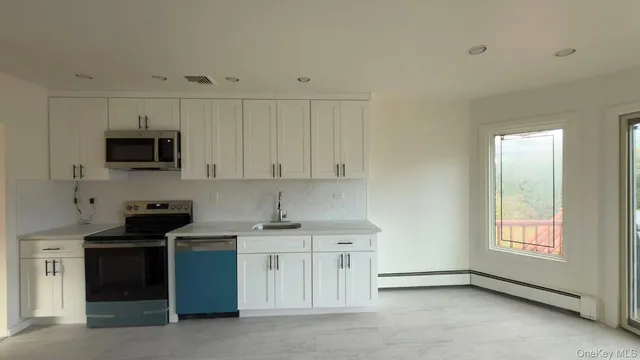 a kitchen with stainless steel appliances granite countertop a sink stove and microwave