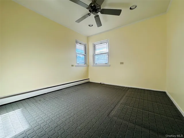 an empty room with a ceiling fan and window