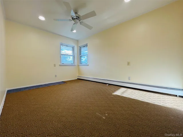 an empty room with a ceiling fan and window