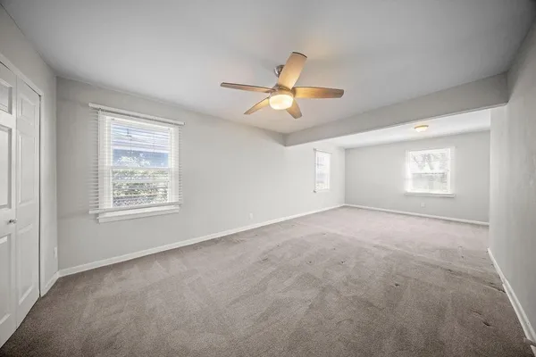 a view of a livingroom with a ceiling fan and window